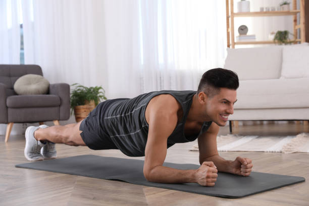 istock Handsome man doing plank exercise on yoga mat at home 1426217223