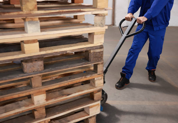 istock Worker moving wooden pallets with manual forklift in warehouse, closeup 1426218186