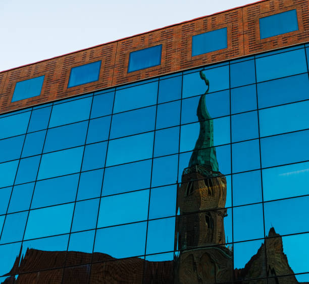 Reflection of the old temple in the facade of a new modern mirror building. Old and modern architecture of Wroclaw