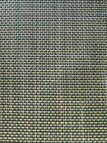 Colored plastic woven texture of a table mat that can be used as a pattern background.