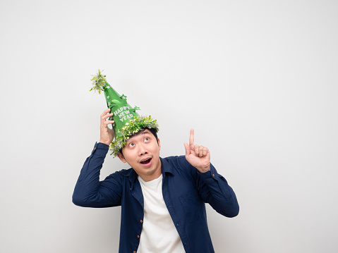 Man wearing green hat feeling happy point finger up at copy space