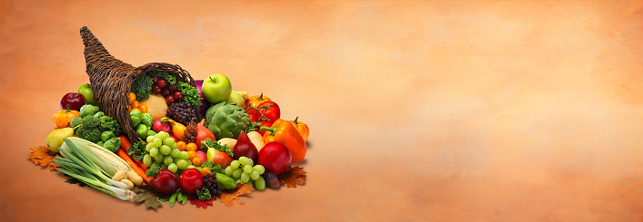 A Thanksgiving cornucopia of fruits and vegetables on an elegant painted backdrop that provides ample room for copy and text.