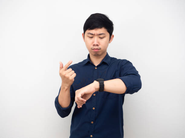 istock Asian man looking at his watch and counting finger serious emotion 1426224234