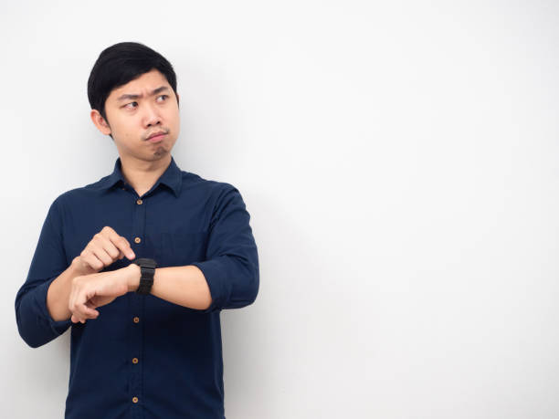 istock Man wearing watch serious emotion looking at copy space white background 1426224343
