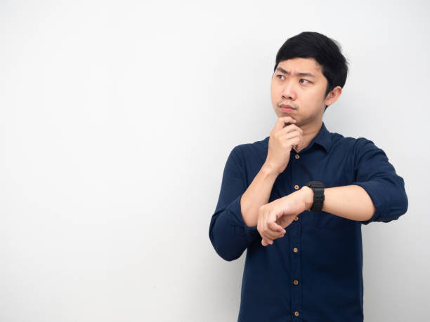 homem asiático mostrar seu relógio sentindo hesitação olhando para copiar fundo branco espaço - clock clock face blank isolated - fotografias e filmes do acervo