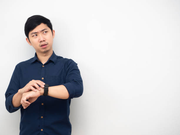 istock Man wearing watch feeling strain looking at copy space white background 1426224700