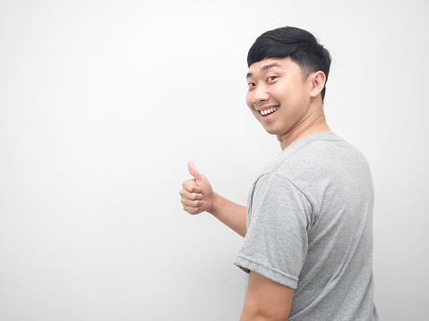 Asian man turn back for thumb up with happy smile emotion copy space