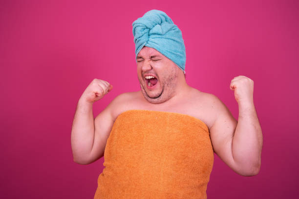 istock Funny fat man is washing himself in the shower. 1426228085