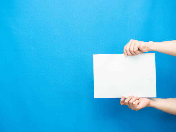 istock Man hand show white paper empty blue background copy space 1426229126