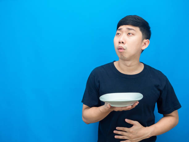 istock Man feeling hungry holding dish and looking at copy space thiking about dinner 1426230282