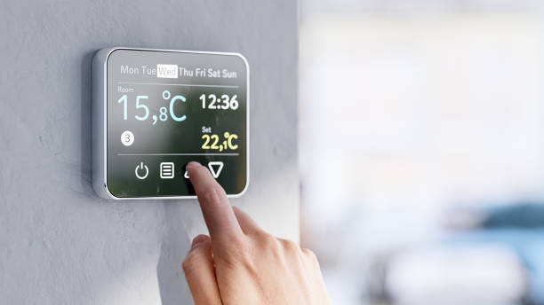 istock Setting room temperature on wall thermostat - Low winter temperatures in homes caused by the energy crisis in Europe 1426232153