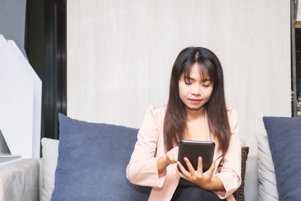 istock close up business woman hands using smartphone tablet typing and touch on white screen for working with app devices vintage style sitting on sofa in lobby office. 1426234432
