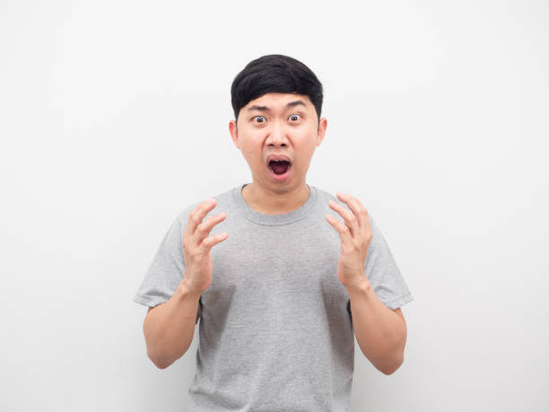 istock Man feeling amazed emotion grey shirt white background 1426235674