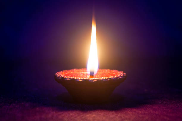 istock Happy Diwali - Clay diya lamp lit during diwali celebration 1426236422