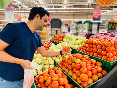 Latin man choosing vegetables in a market