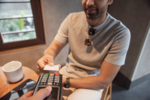 istock Indian man making payment, sitting in a coffee shop 1426237570