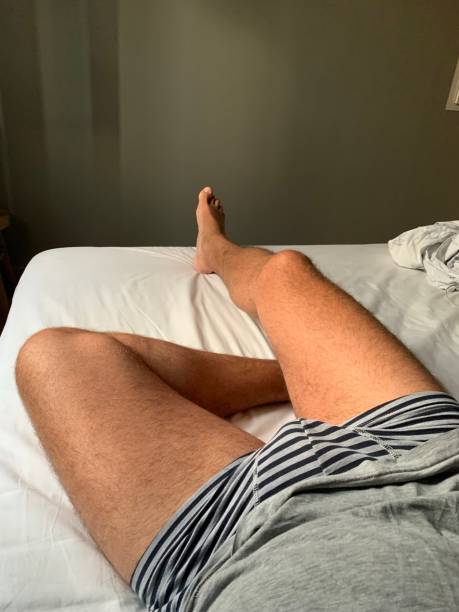 istock Tanned bare legs in bed. 1426238927