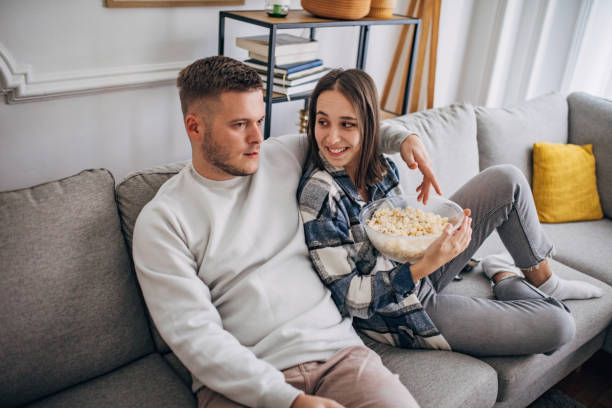 istock Young couple relaxing at home watching TV 1426239269
