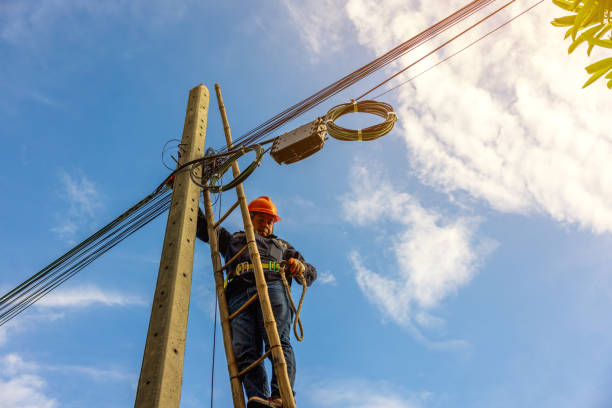 istock A telecoms worker is shown working from a utility pole ladder while wearing high visibility personal safety clothing, PPE, and a hard hat. 1426239797