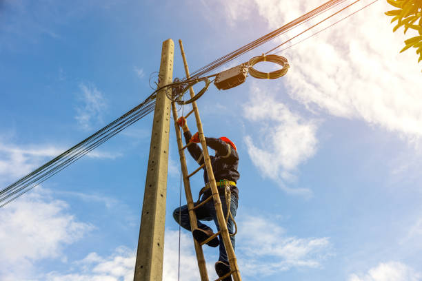 istock A telecoms worker is shown working from a utility pole ladder while wearing high visibility personal safety clothing, PPE, and a hard hat. 1426239801