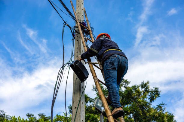 istock A telecoms worker is shown working from a utility pole ladder while wearing high visibility personal safety clothing, PPE, and a hard hat. 1426239844