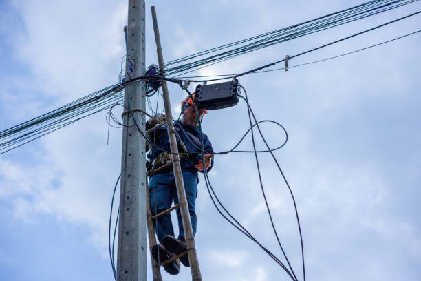 istock A telecoms worker is shown working from a utility pole ladder while wearing high visibility personal safety clothing, PPE, and a hard hat. 1426239865