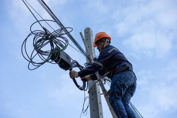 istock A telecoms worker is shown working from a utility pole ladder while wearing high visibility personal safety clothing, PPE, and a hard hat. 1426239867