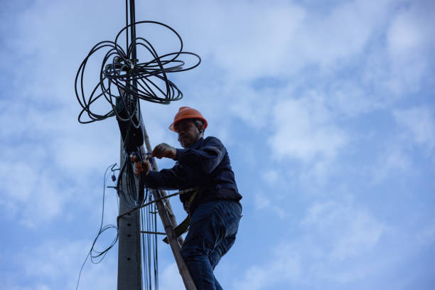 istock A telecoms worker is shown working from a utility pole ladder while wearing high visibility personal safety clothing, PPE, and a hard hat. 1426239871