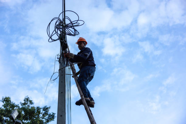 istock A telecoms worker is shown working from a utility pole ladder while wearing high visibility personal safety clothing, PPE, and a hard hat. 1426239892