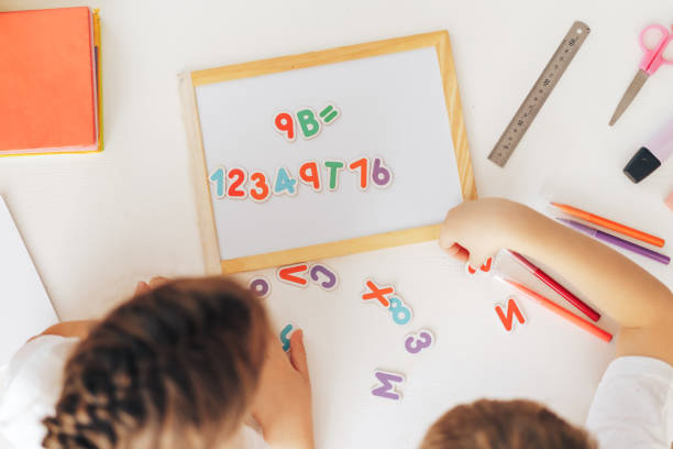 istock Children study the letters on the magnet and put them in a row on the board 1426240036