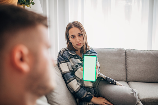 Girlfriend shows text message on phone to boyfriend