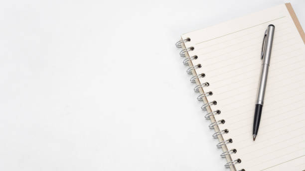 istock Silver pen and notebook blank page on the table top view copy space 1426242038