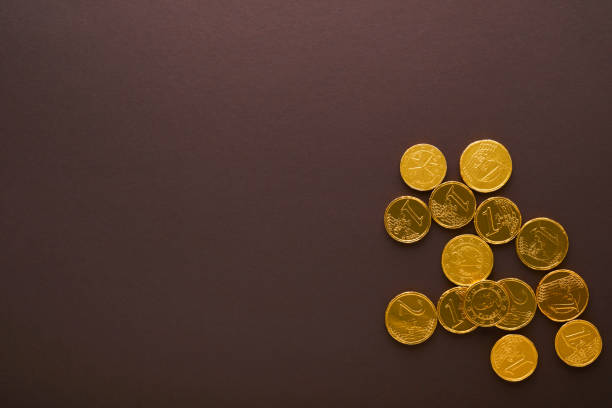 Chocolate coin. Backgrounds of chocolate Euro coin money on brown background. Euro coins stacked on each other in different positions. Group of coins. Mock up. Chocolate coin. Backgrounds of chocolate Euro coin money on brown background. Euro coins stacked on each other in different positions. Group of coins. Mock up. gold ira reviews stock pictures, royalty-free photos & images