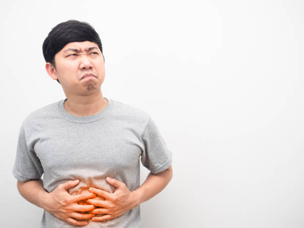 istock Man grey shirt gesture stomach ache feeling unhappy looking at copy space 1426245278