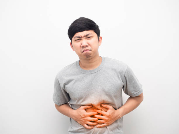istock Man grey shirt gesture stomach ache feeling unhappy 1426245428