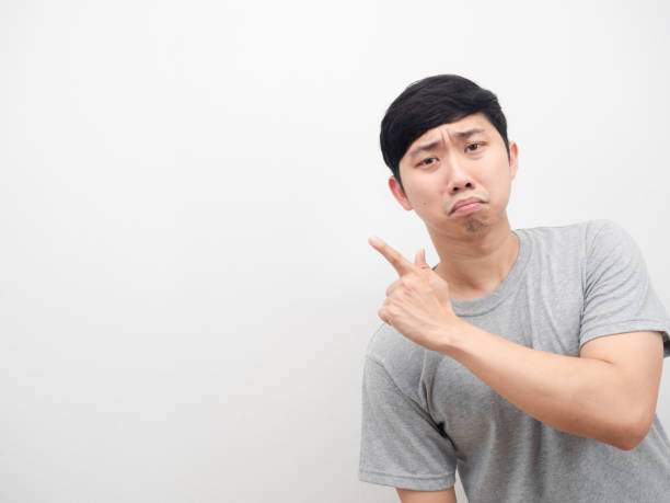 istock Asian man sad emotion point finger at copy space grey shirt 1426245438