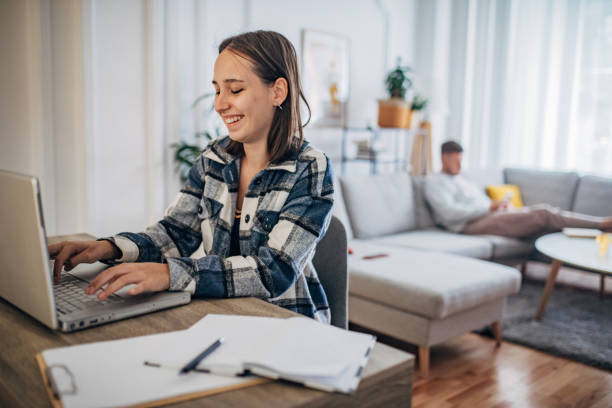 istock Young woman working from home while her boyfriend using smart phone next to her 1426245455