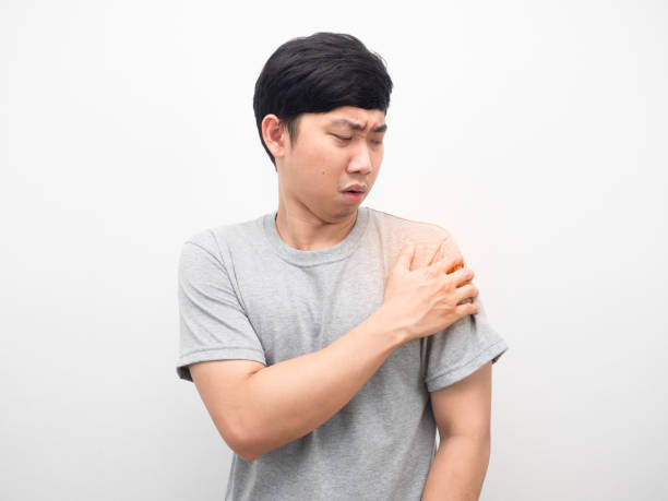 istock Man grey shirt gesture pain his shoulder white background 1426245465