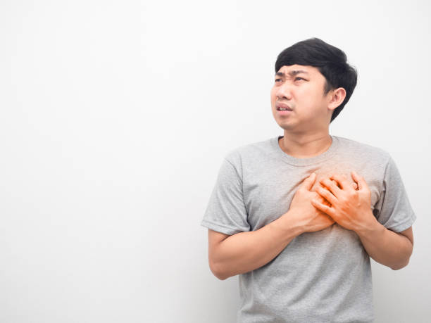 istock Man gesture hurt his chest looking at copy space 1426245475