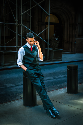 Young Man talking on cell phone outdoors on street in New York City