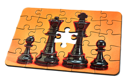 Jigsaw puzzle, with one missing piece, chess pieces representing a nuclear family.