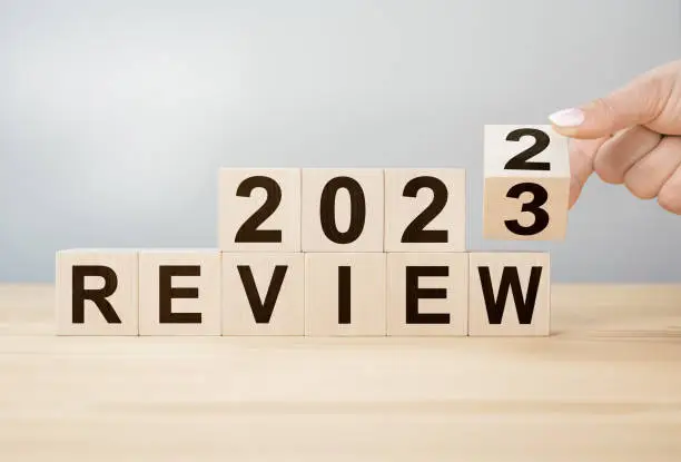 Photo of 2023 review new year. Business concept of planning 2023. Businessman hand flips wooden cube and changes inscription Review 2022 to Review 2023. new year resolution.