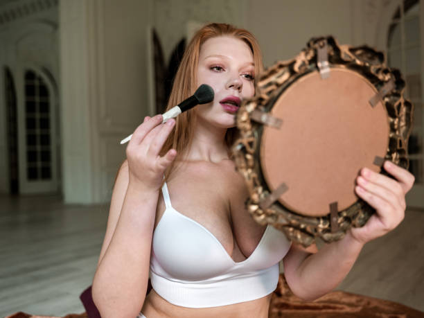 istock Young Caucasian redhead woman doing make up 1426251754