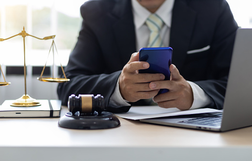 El abogado de la oficina usa un teléfono celular. Concepto moderno de asesoramiento legal de texto. photo