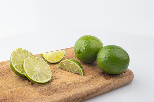 Green lime with cut in half on cutting board