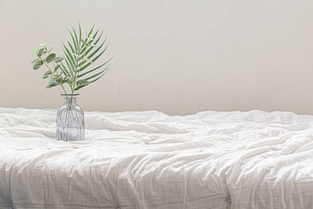 a small glass vase on bed stock photo