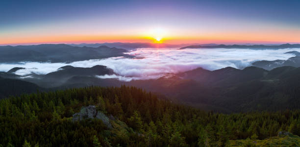 istock Panorama with amazing sunrise. Landscape with high mountains. Fields and meadow are covered with morning fog and dew. Touristic resort Carpathian national park, Ukraine Europe. Natural scenery. 1426254763