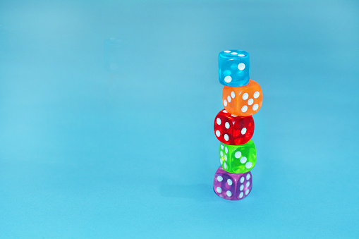 Dice of various colors in a tin box.
