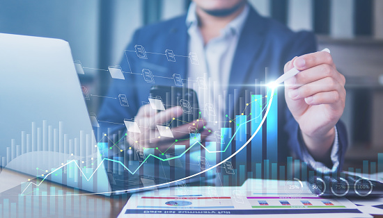 Businessman analyzing for financial and investment growing graph by digital augmented reality graphics, people pointing and calculates financial data and investment stock graph, success graph.