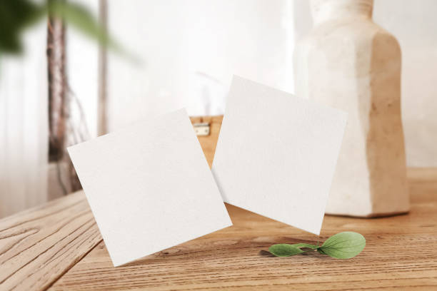 istock Clean minimal square flyer mockup floating on top table with leaves and plant 1426259000